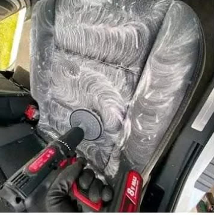 Vehicle seat being scrubbed during interior detailing